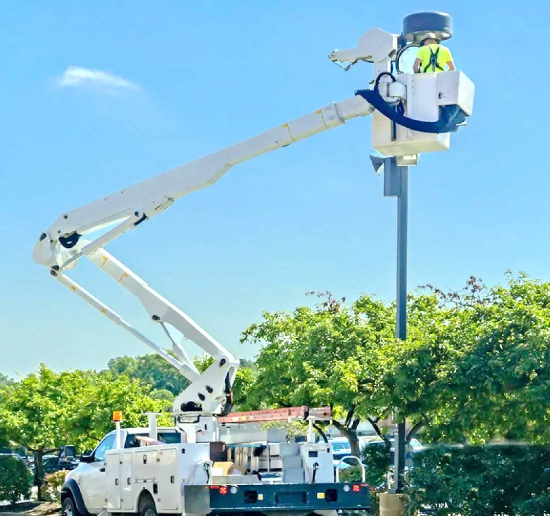 Bucket truck raised to a light pole fixture