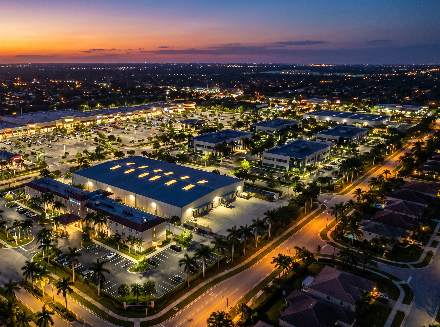 Aerial view of a lit South Florida commercial district at dusk